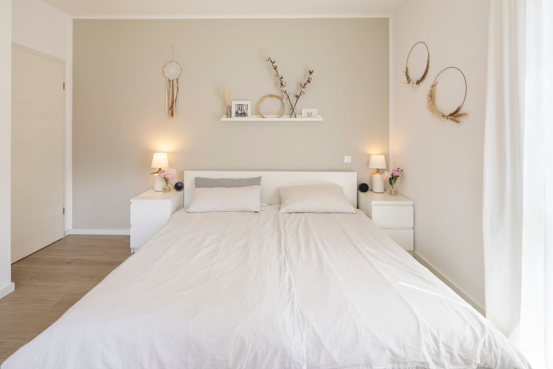 Helles Schlafzimmer in einem frei geplanten FingerHaus mit Doppelbett, sanften Naturtönen und minimalistischer Dekoration für eine ruhige Atmosphäre.