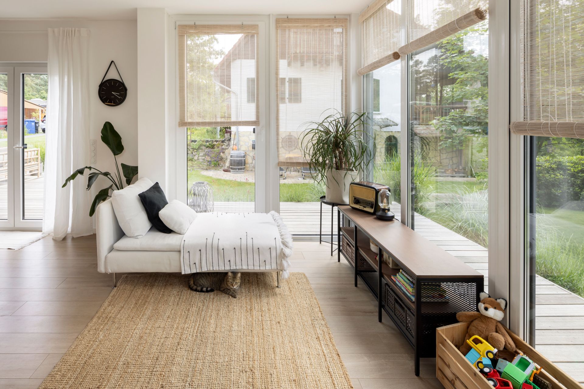 Heller Wintergarten eines frei geplanten FingerHauses mit moderner Einrichtung, großen Fensterflächen und Blick in den Garten.