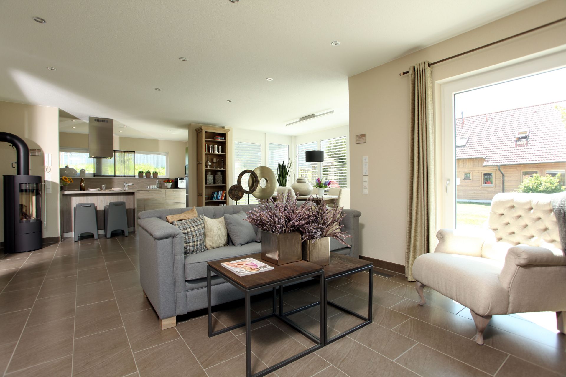 Offener Wohn- und Küchenbereich im MEDLEY 310, Musterhaus Erfurt, mit gemütlicher Sitzecke.