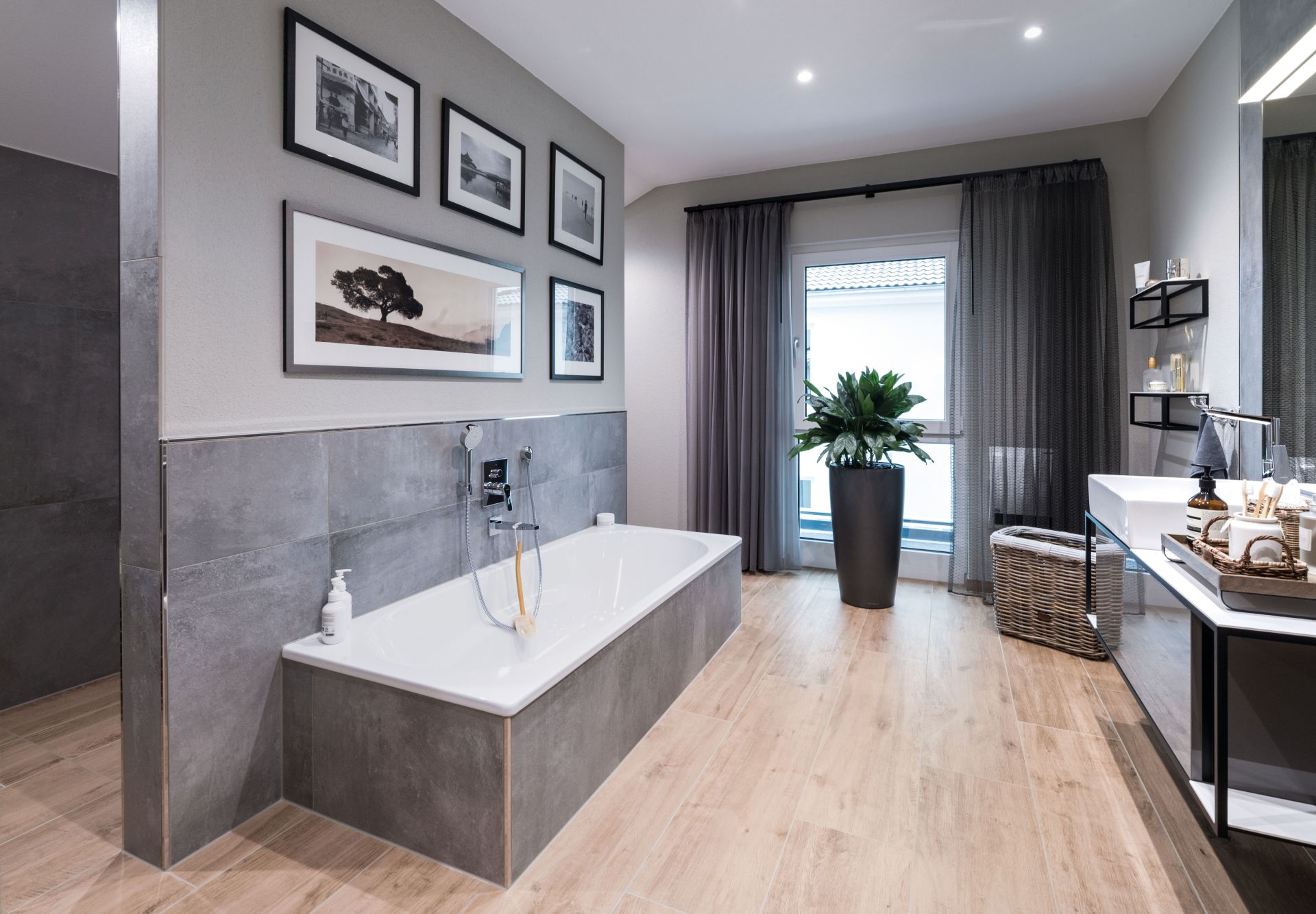 Modernes Badezimmer mit freistehender Badewanne, großem Waschtisch und eleganter Gestaltung im Musterhaus MEDLEY 300 B in Poing.