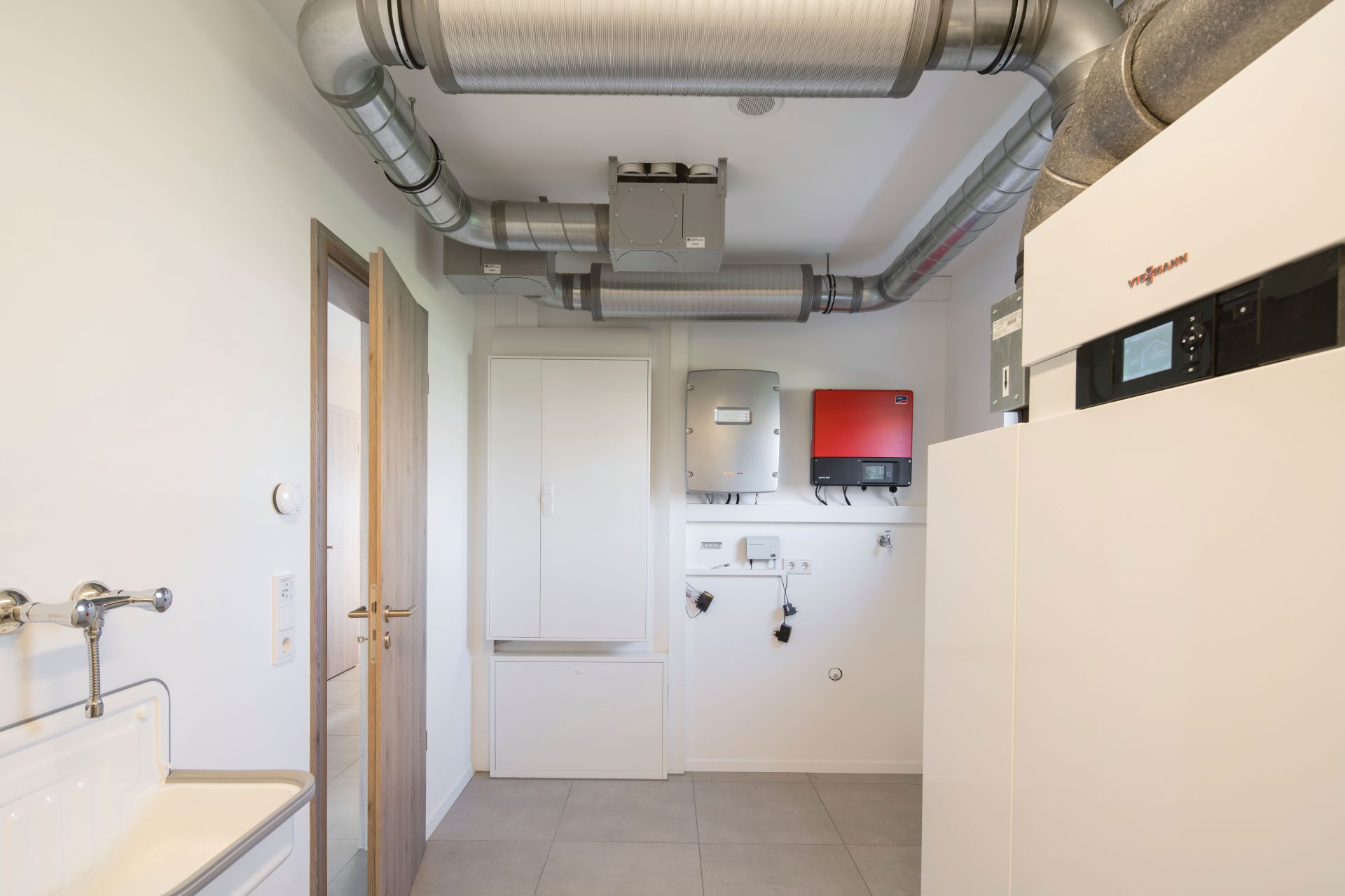 Hauswirtschaftsraum im FingerHaus NEO Musterhaus Günzburg mit moderner Heizungs- und Lüftungstechnik sowie praktischem Waschbecken.