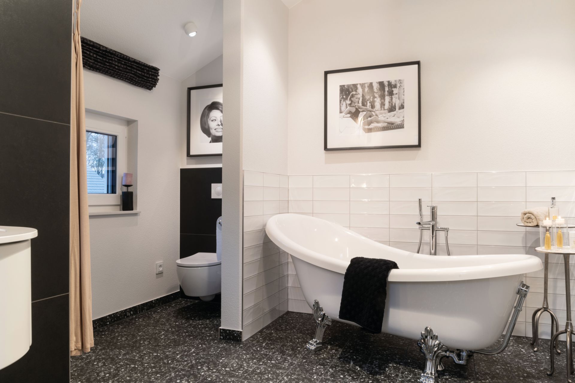 Modernes Badezimmer im Musterhaus SENTO 503 in Bad Vilbel mit freistehender Badewanne und stilvoller Einrichtung.