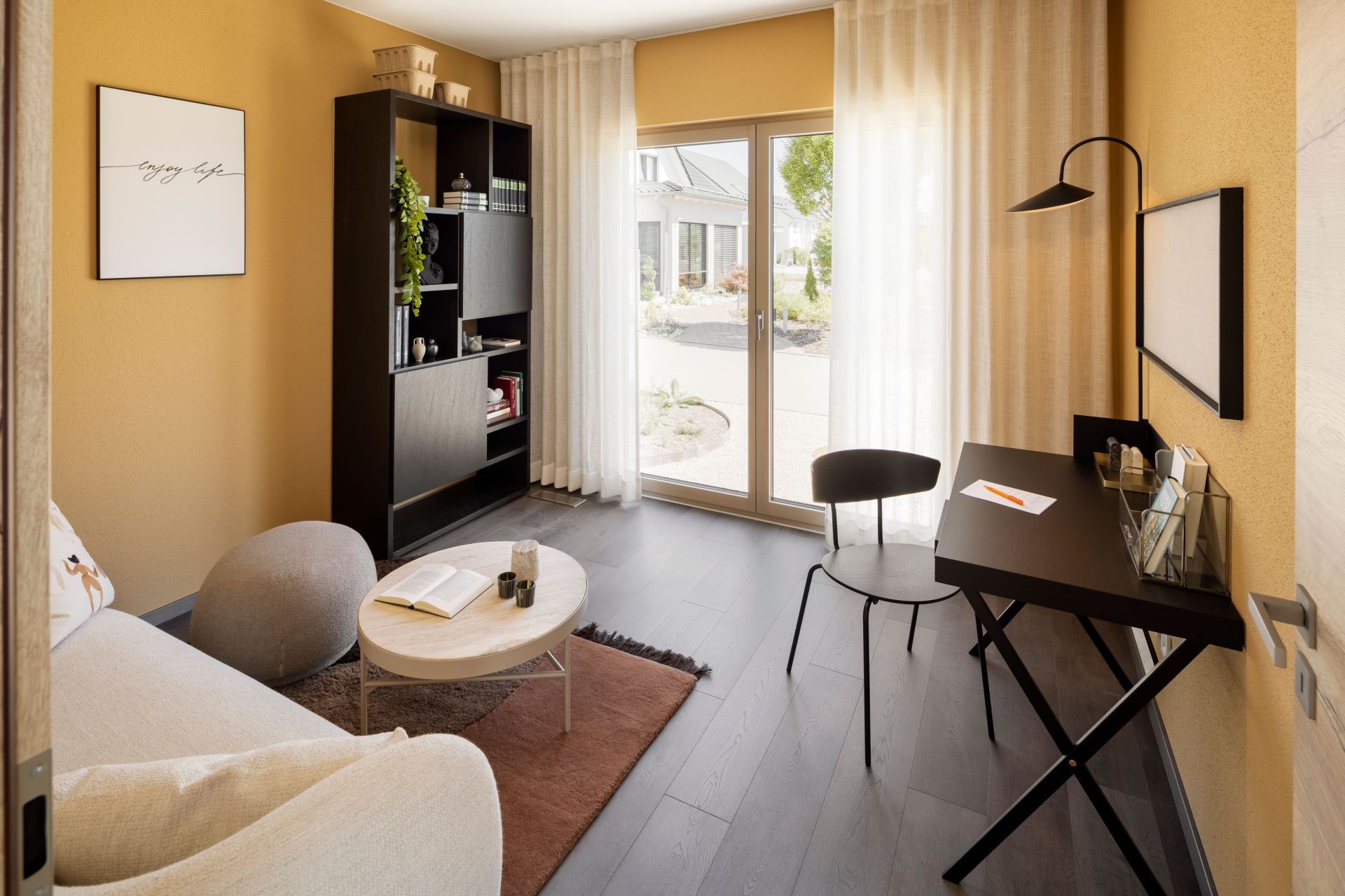 Modern eingerichtetes Homeoffice im FingerHaus ARTIS 300 Musterhaus Nürnberg mit Schreibtisch, Sofa und Zugang zur Terrasse.