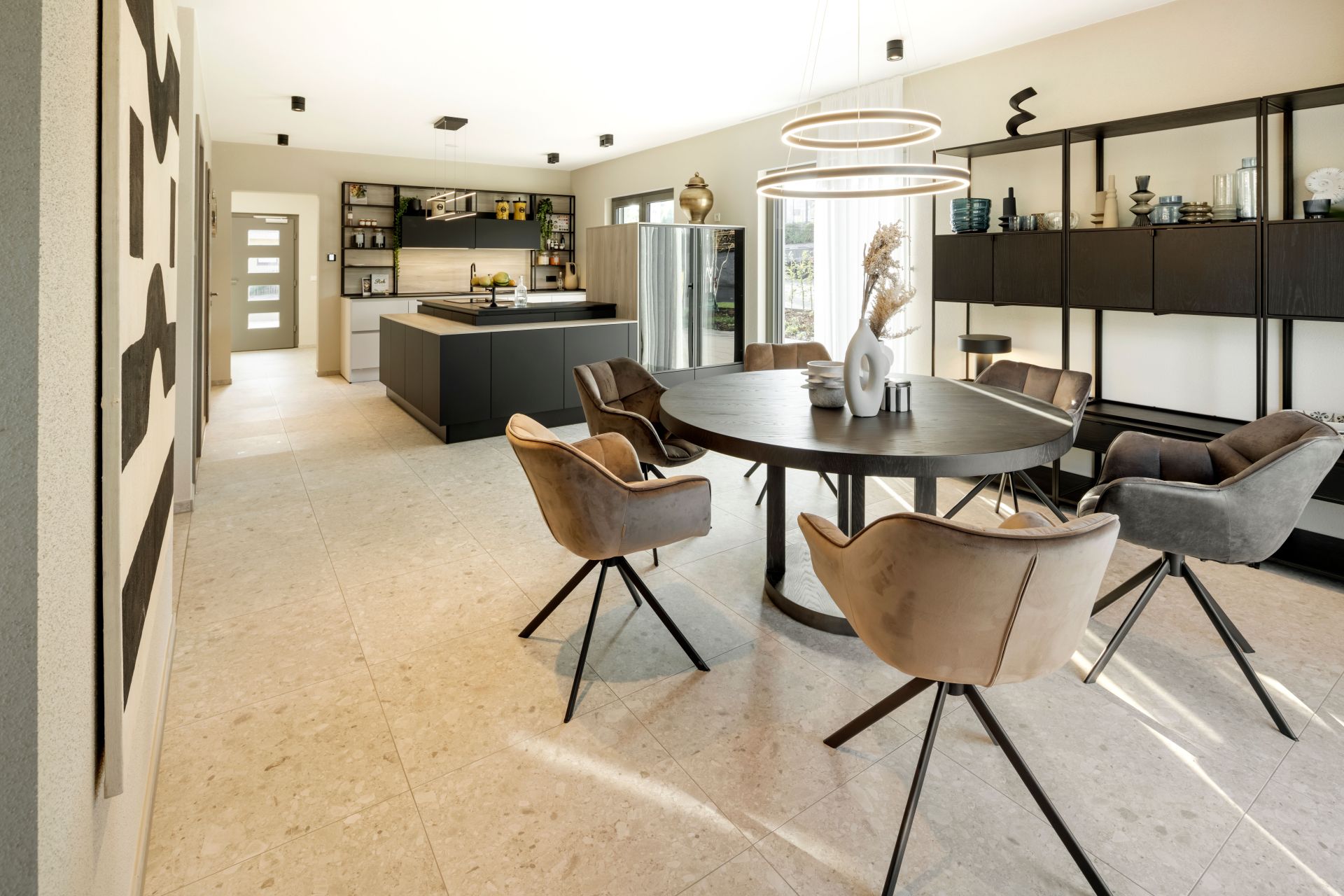 Moderner Essbereich im FingerHaus ARTIS 300 Musterhaus Würzburg mit rundem Esstisch, eleganten Stühlen und offener Verbindung zur Designküche.