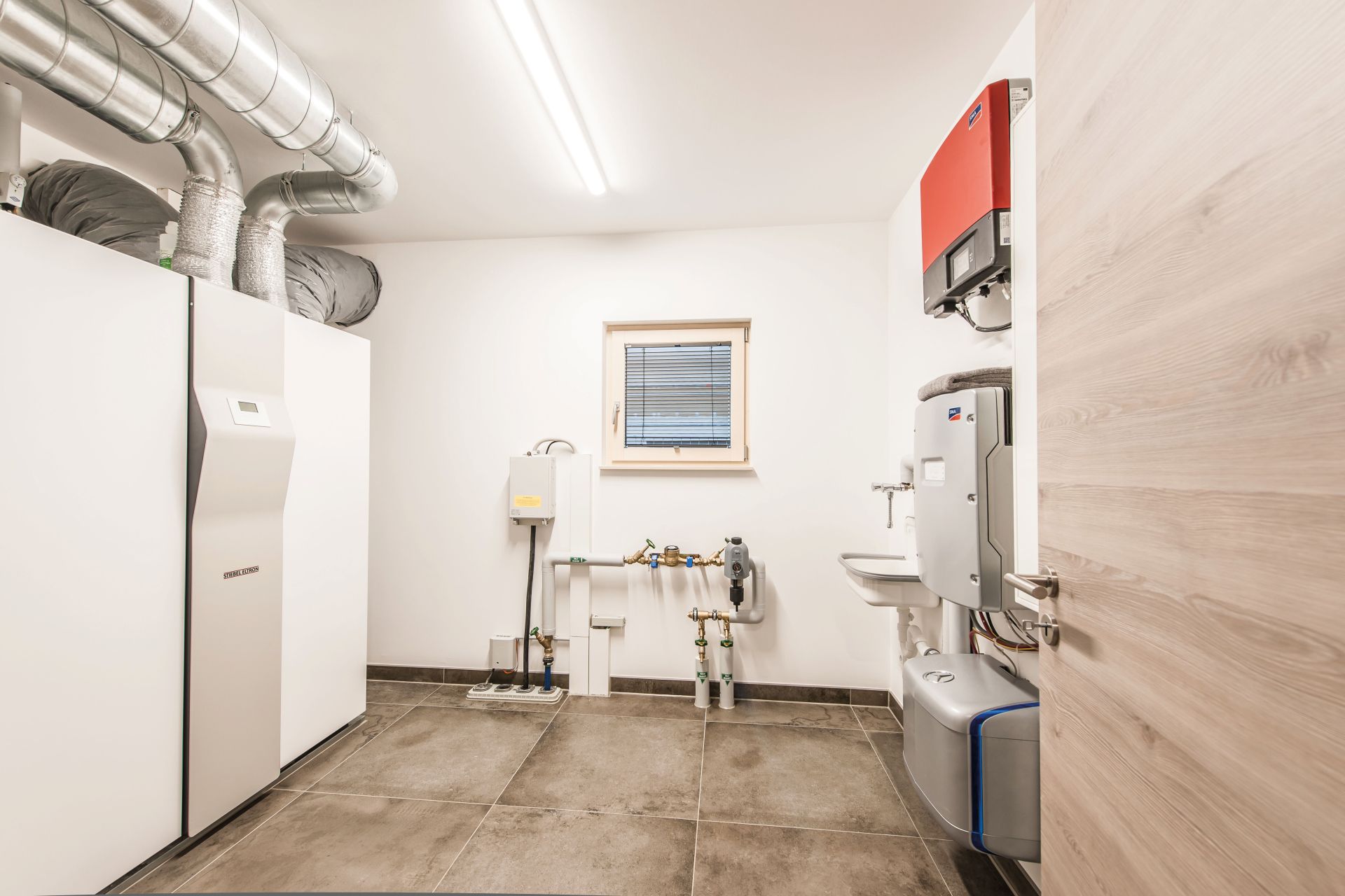 Hauswirtschaftsraum im Musterhaus MEDLEY in Fellbach mit moderner Haustechnik, Wärmepumpe und praktischer Ausstattung.