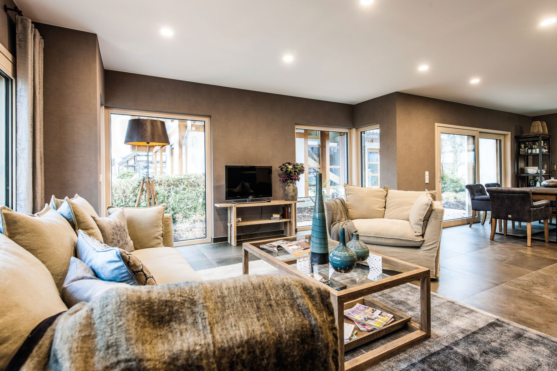 Helles Wohnzimmer im Musterhaus MEDLEY in Fellbach mit gemütlichen Sofas, moderner Einrichtung und offenem Übergang zum Essbereich.