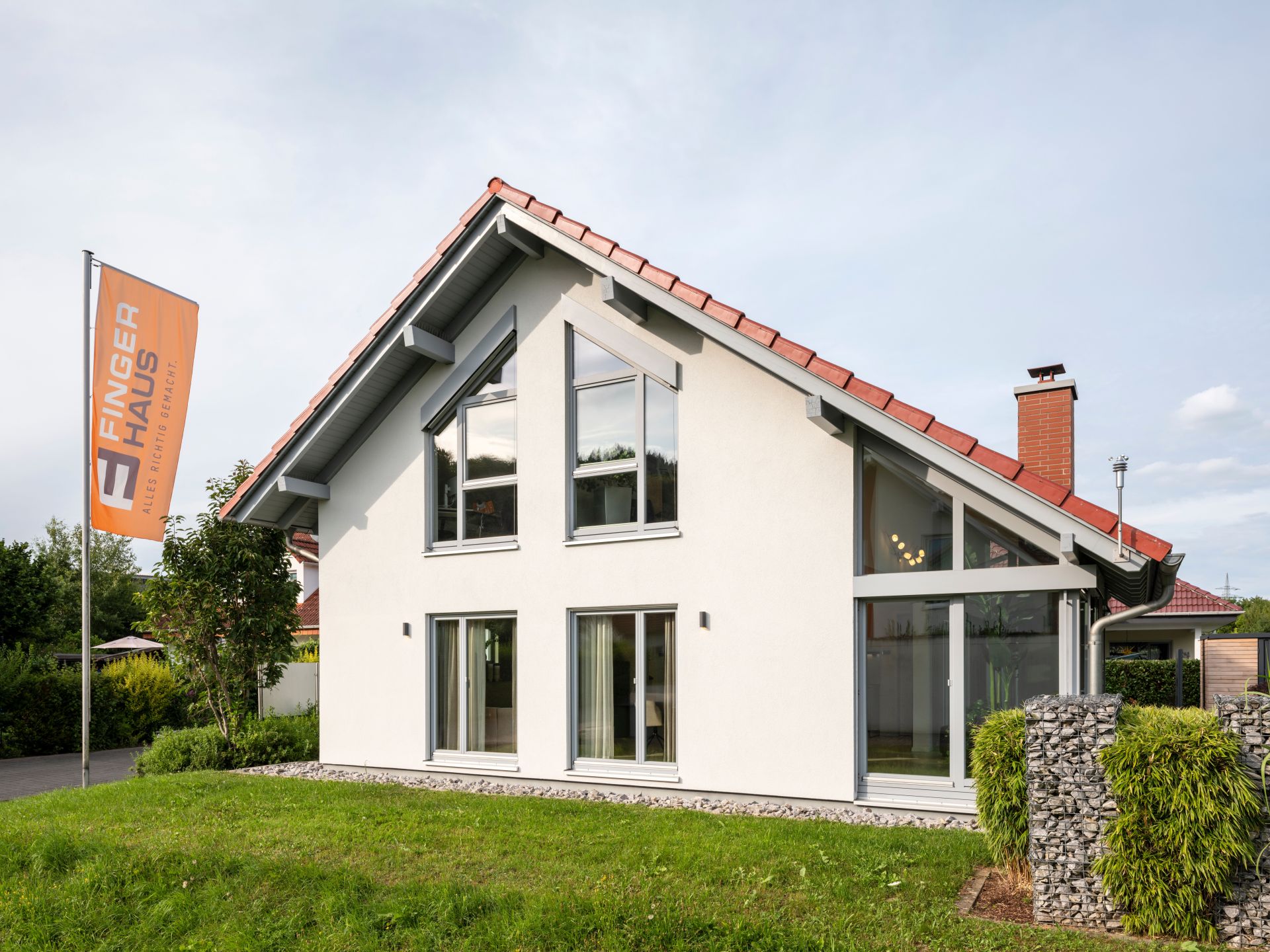 Außenansicht des frei geplanten FingerHaus Musterhauses in Marburg mit modernem Satteldach und großen Fenstern.