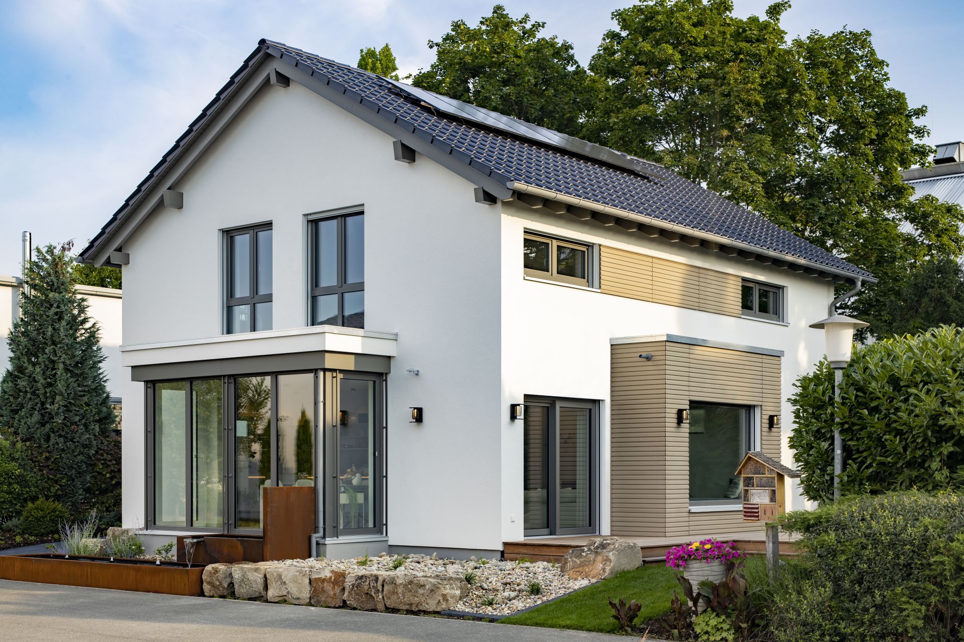 Modernes Musterhaus MEDLEY in Mannheim mit weißer Fassade, großen Fenstern und eleganten Holzdetails.