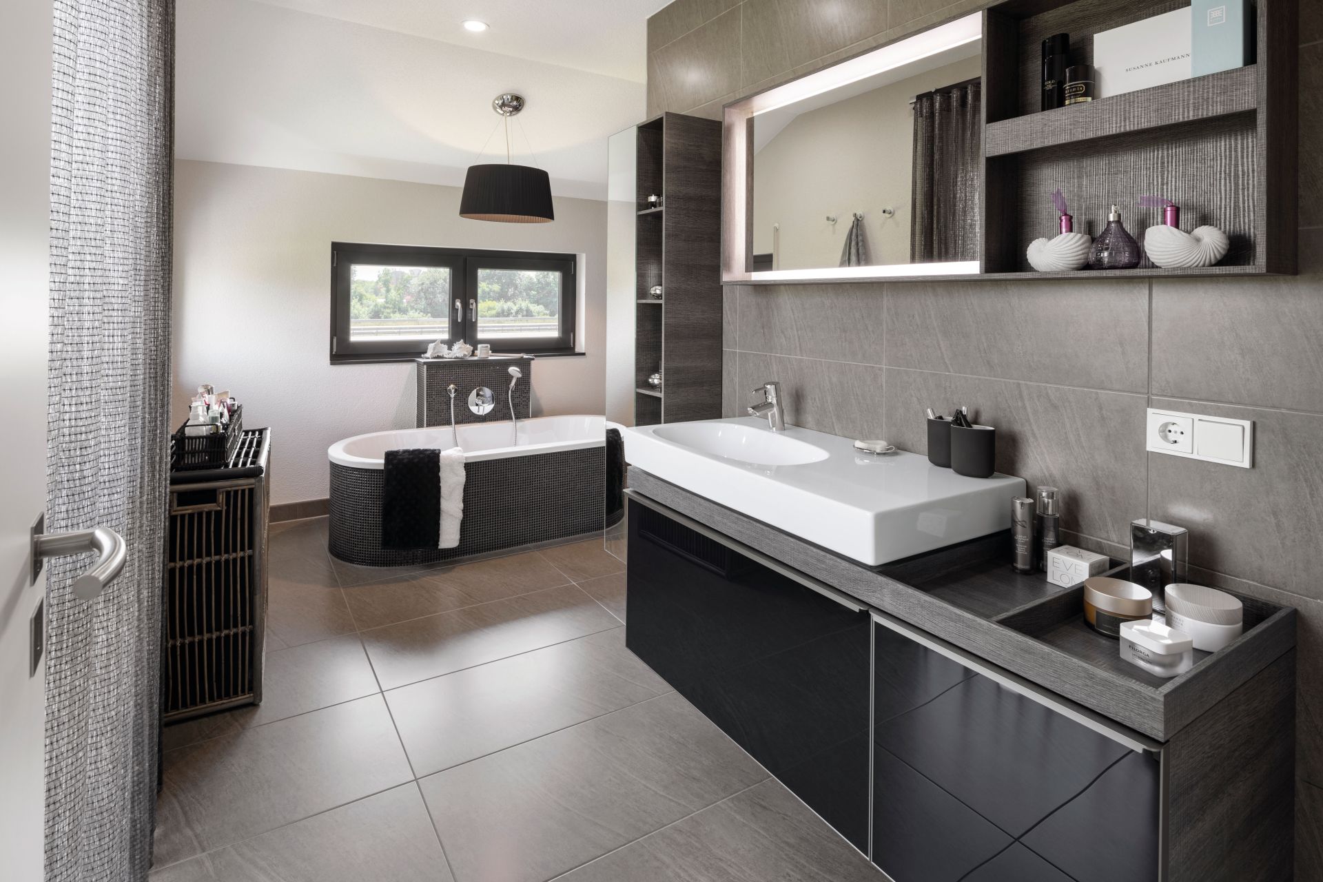 Luxuriöses Badezimmer im FingerHaus NEO 300 Musterhaus Hannover mit freistehender Badewanne, großem Waschtisch und modernen Fliesen.