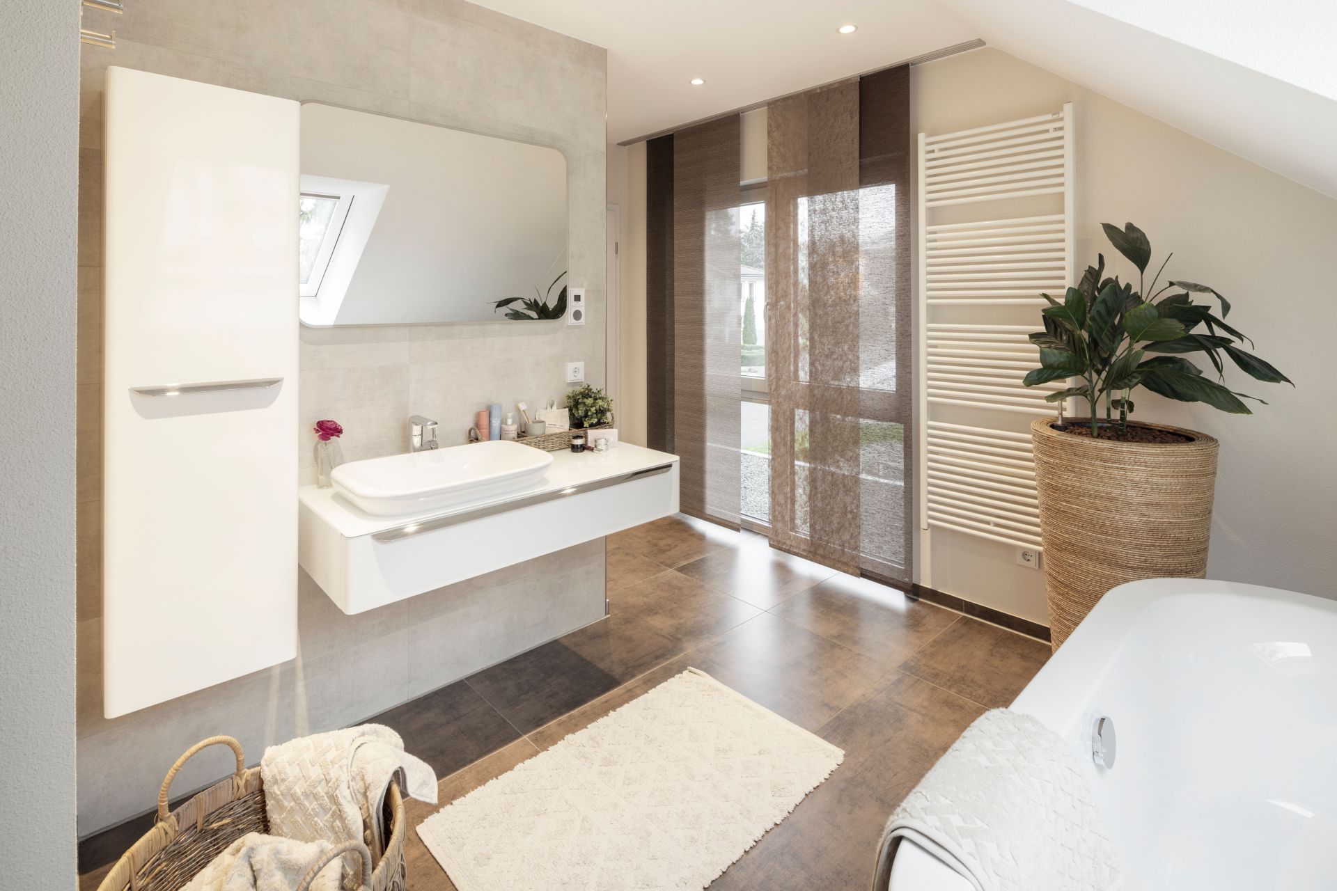 Helles Badezimmer im Musterhaus NEO 312 in Bad Vilbel mit großem Spiegel, modernem Waschtisch, Badewanne und stilvollen Details.