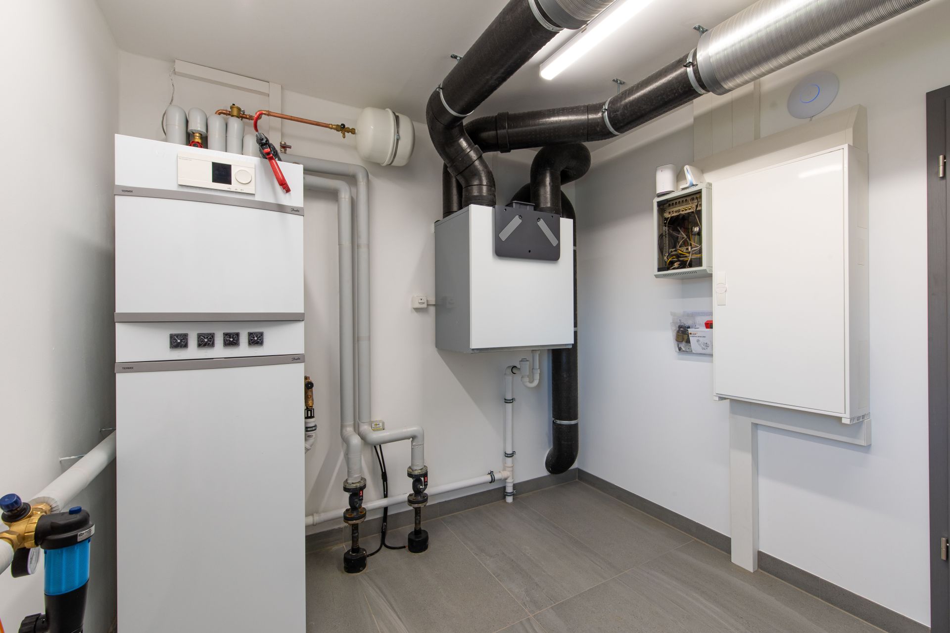 Hauswirtschaftsraum im FingerHaus Musterhaus TALO in Babenhausen mit moderner Haustechnik, Heizungsanlage, Lüftungssystem und Stromverteilerkasten. Funktionaler Raum mit klarer Struktur und hochwertiger Ausstattung.