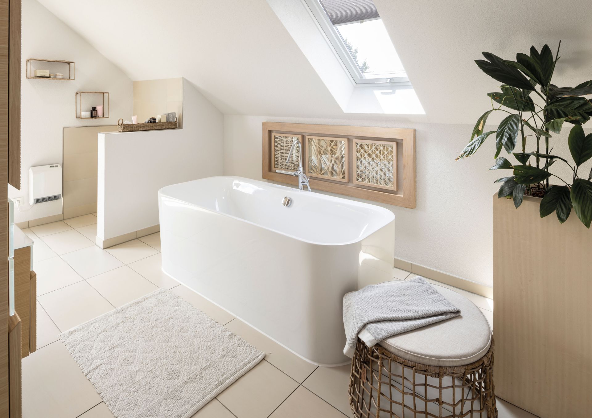 Modernes Badezimmer im Dachgeschoss mit freistehender Badewanne, Dachfenster und natürlicher Dekoration im Musterhaus VIO Köln.