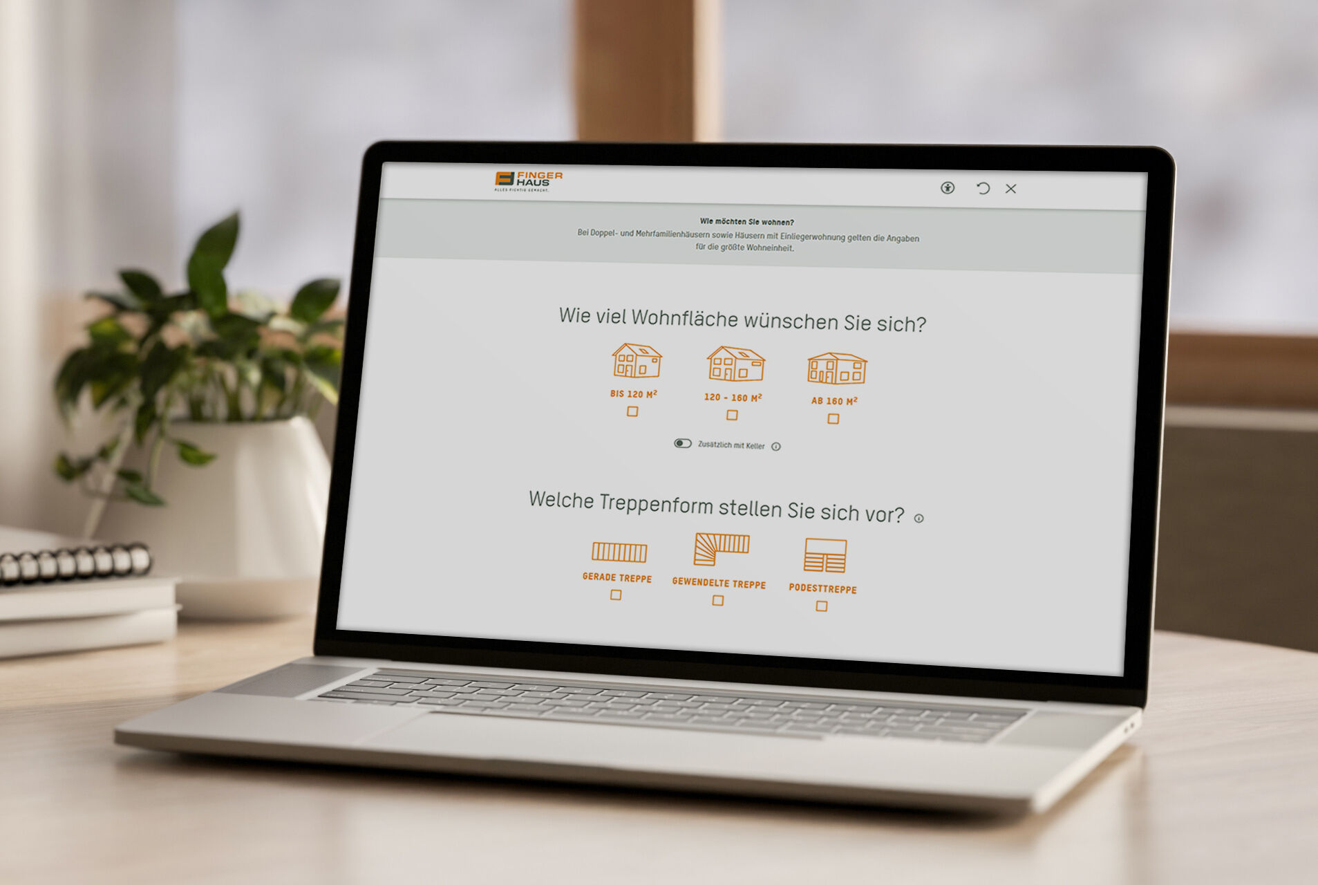 Zweite Seite des digitalen Hausplaner-Tools „Hausfinder“ von FingerHaus auf einem Laptop, mit Auswahl zur gewünschten Wohnfläche und Treppenform.