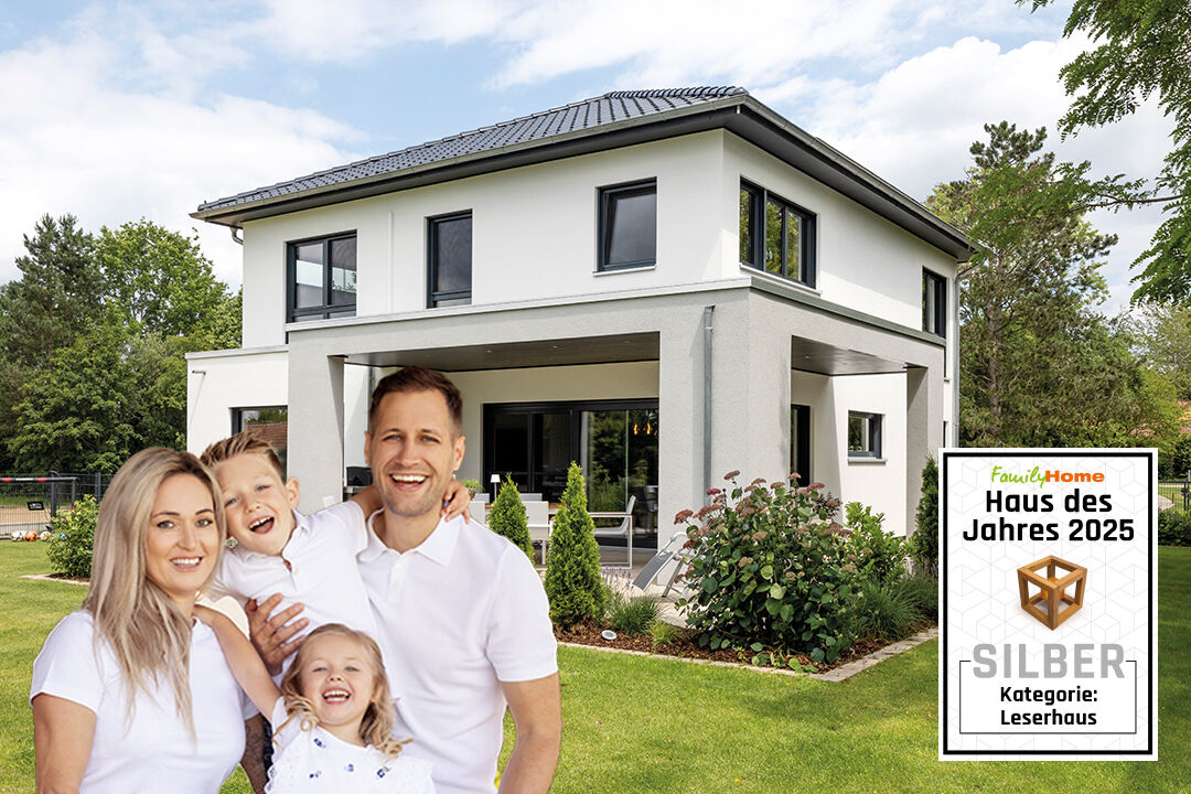 Modernes, zweigeschossiges FingerHaus mit Garten; davor lächelnde vierköpfige Familie. Ausgezeichnet als „Haus des Jahres 2025“ in Silber in der Kategorie Leserhaus.