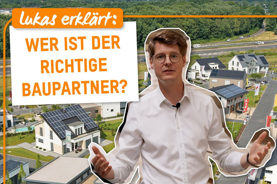 Mann erklärt vor moderner Haussiedlung, worauf es bei der Wahl des richtigen Baupartners ankommt
